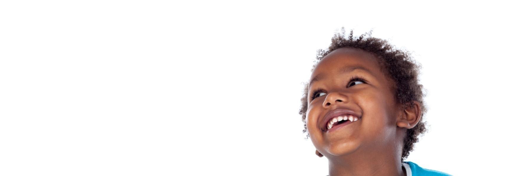 Toddler smiling and looking up at pediatric dentist near me